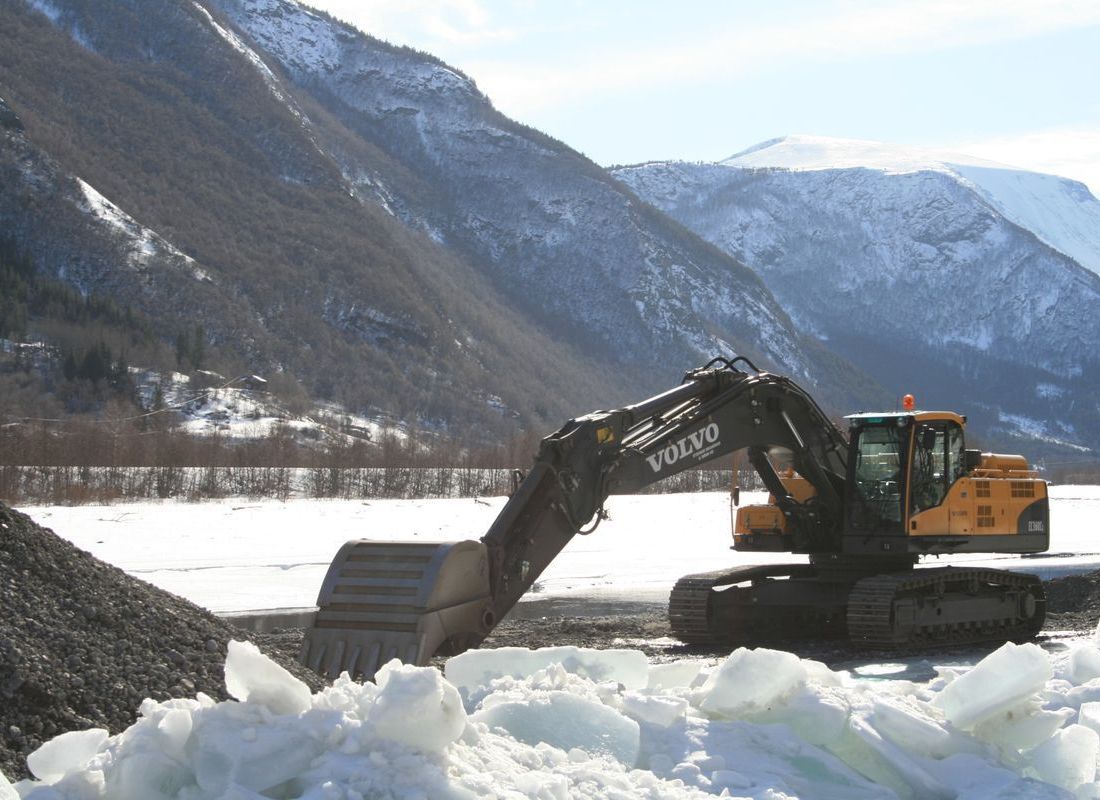 Gravemaskin Volvo EC 380i arbeid om vinteren med fjell i bakgrunnen